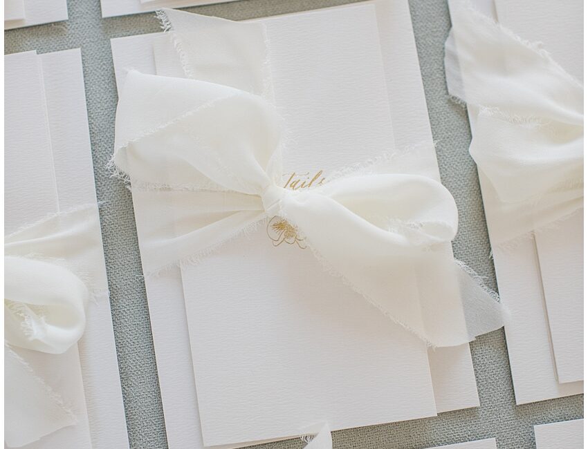 minimal and elegant gold foil pressed wedding invitations with fold out details card wrapped with cream chiffon ribbon